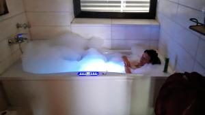 a woman is in a bath tub with steam at African Lodge im Pilgerglück in Jüchen