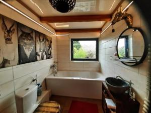 y baño con bañera y lavamanos. en African Lodge im Pilgerglück, en Jüchen