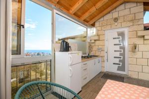 a kitchen with a refrigerator and a large window at Sunny rooms in Dubrovnik