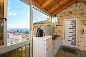 a kitchen with a window and a view of the ocean at Sunny rooms in Dubrovnik