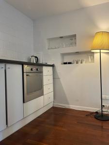 a kitchen with a stove and a table with a lamp at Labo Apartment Chmielna in Warsaw