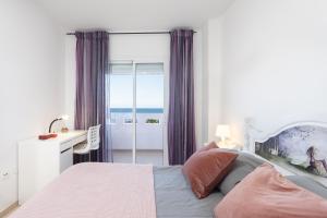een slaapkamer met een bed en uitzicht op de oceaan bij Home2Book Sea Front Duplex Terrace Pool in Puertito de Güímar