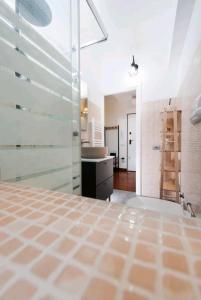 uma casa de banho com uma cabina de duche em vidro e um lavatório. em Maison Indipendenza em Bolonha