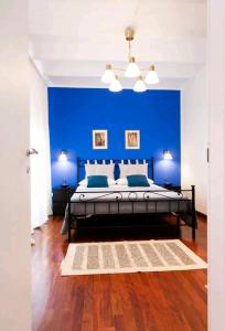 um quarto azul com uma cama e uma parede azul em Maison Indipendenza em Bolonha