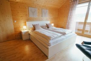 una camera con un letto su una parete in legno di Ferienwohnung Karawankenblick a Rosegg