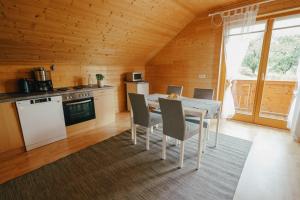 een keuken en eetkamer met een tafel en stoelen bij Ferienwohnung Karawankenblick in Rosegg