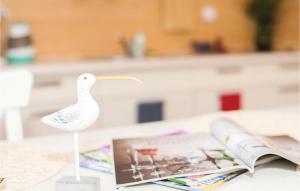 a plastic white bird on a table next to a magazine at Beautiful Home In Ustka With Kitchen in Ustka