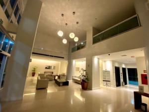uma ampla sala de estar com sofás e um lustre em Saint Moritz no coração de Brasília em Brasília