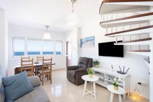 een woonkamer met een bank en een tafel bij Home2Book Sea Front Duplex Terrace Pool in Puertito de Güímar