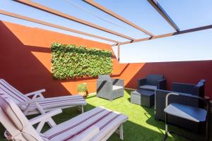 a patio with chairs and a wall with a plant at Home2Book Sea Front Duplex Terrace Pool in Puertito de Güímar