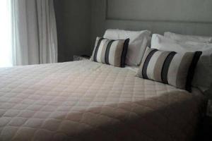 a bedroom with a large bed with pillows at Brisas do Lago - Apartamento 7 in Brasilia