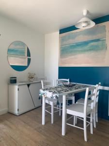 een eetkamer met een witte tafel en stoelen bij Vue mer, superbe appartement refait à neuf! in Talmont
