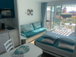 Cette chambre comprend un lit et une cuisine avec un balcon. dans l'établissement Vue mer, superbe appartement refait à neuf!, à Talmont-Saint-Hilaire