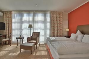 ザルシュテットにあるホテル ゲデッケのベッドルーム1室(ベッド1台、椅子、デスク付)