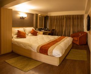 a bedroom with a large bed and a chair at Hotel Traditional in Bhaktapur