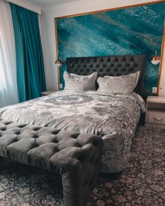 a bedroom with a large bed with a large headboard at Suru Hotel & Restaurant in Buşteni