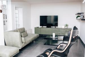 - un salon avec un canapé et une télévision dans l'établissement Gadering, à Zele