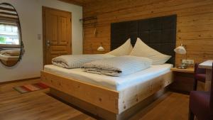 ein Schlafzimmer mit einem Bett mit einer Holzwand in der Unterkunft Haus Petra in Bach