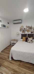 a white bedroom with a bed and a wooden floor at Marlin I Puerto del Carmen in Puerto del Carmen