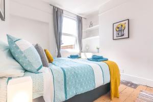 a bedroom with a bed with a blue blanket and a window at Chestnut House Exeter in Exeter