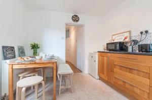 a kitchen with a table and chairs and a microwave at Chestnut House Exeter in Exeter