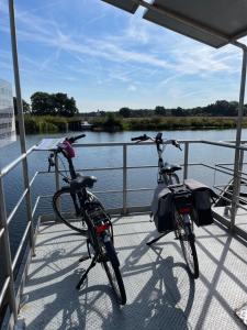 two bikes parked on a boat on a river at Hotel De Barones in Dalfsen