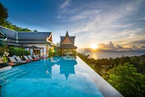 a pool at a villa with the sunset in the background at Baan Phu Prana Boutique Villa in Surin Beach