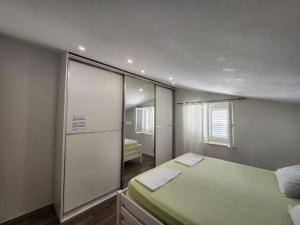 a small room with a bed and a mirror at Sunny rooms in Dubrovnik