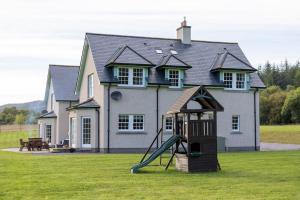 Beallach Lodge في Culrain: ملعب أمام منزل به زحليقة