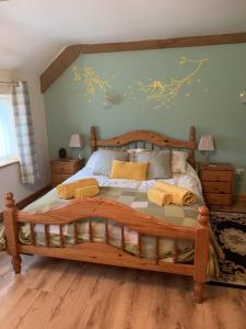Un dormitorio con una gran cama de madera con almohadas amarillas. en Blaencwm Cottages en Boncath
