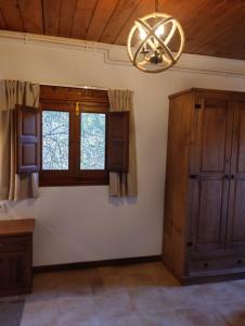 une salle à manger avec un lustre et des fenêtres dans l'établissement Masia La Clariana, à Castelltallat