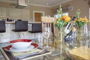 Beallach Lodge في Culrain: طاولة زجاجية مع وعاء وزهور في مطبخ