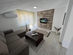 - un salon avec un canapé et une table dans l'établissement Апартамент Панорама Рози, à Sandanski