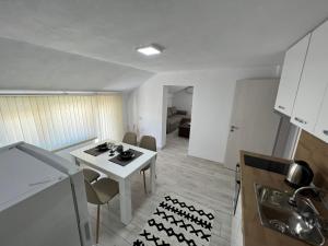 - une cuisine avec une table et des chaises blanches dans la chambre dans l'établissement Апартамент Панорама Рози, à Sandanski