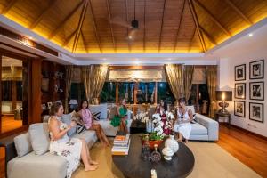 a group of women sitting in a living room at Baan Phu Prana Boutique Villa in Surin Beach