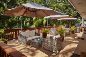 eine Terrasse mit Stühlen und einem Tisch mit einem Sonnenschirm in der Unterkunft Contadora Island Inn in Isla Contadora
