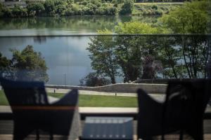 a view of a lake from a balcony with chairs at Vinha Boutique Hotel - The Leading Hotels of the World in Vila Nova de Gaia