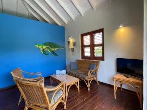 een woonkamer met een bank en een tafel bij Westhill Bungalows & Diving in Sabana Westpunt