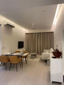 sala de estar con sofá, mesa y sillas en Lovely Continew Residence 2 Bedrooms - KL, en Kuala Lumpur