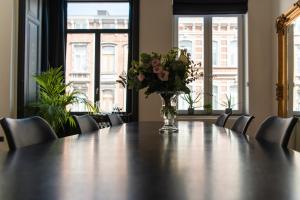 een vaas met bloemen bovenop een tafel bij Appartement Guillemins station in Luik