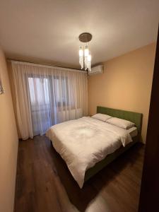 a bedroom with a large bed and a window at Aparthotel Brown in Bucharest