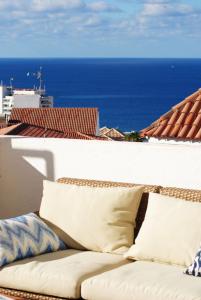 un divano posto in cima a un balcone con vista sull'oceano di Villa Casa Blanca ad Adeje