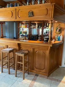 a wooden bar with two stools in a room at Family Hotel Zdravets in Sofia