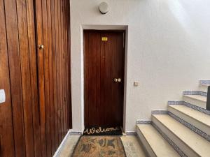 - une porte marron dans un bâtiment avec des escaliers dans l'établissement Quarteira Stylish 1 by Homing, à Quarteira