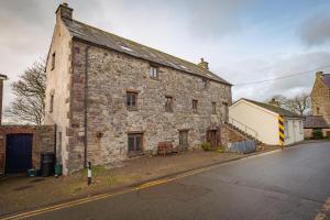 an old stone building on the side of a street at Stunning Converted Granary in Heart of St Davids in St. Davids