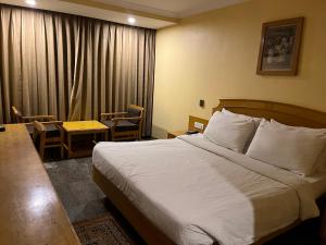 a hotel room with a bed and a table and chairs at ASR Guesthouse in Tirupati
