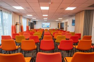 an empty room with chairs and a projection screen at Holiday Inn - Bordeaux-Merignac, an IHG Hotel in Mérignac