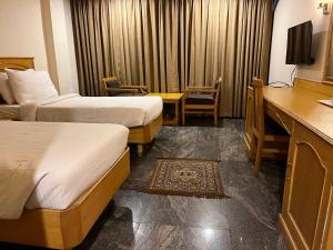 a hotel room with two beds and a desk at ASR Guesthouse in Tirupati