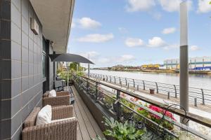 a balcony with chairs and a view of the water at Glasgow Harbour Clyde Waterfront Apartment in Glasgow