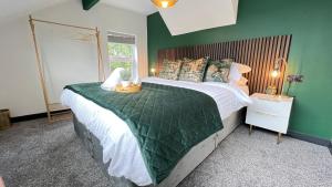 a bedroom with a large bed with a green wall at Park View in Headingley